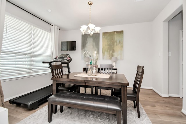 dining area featuring baseboards, a chandelier, and light wood-style flooring