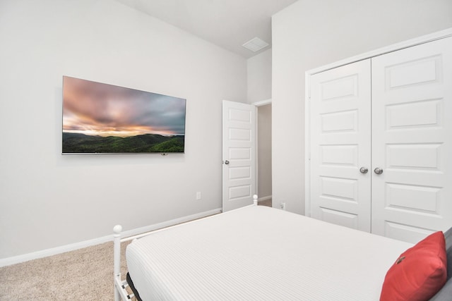 carpeted bedroom featuring a closet and baseboards