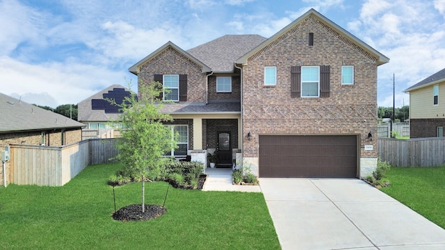 craftsman house featuring driveway, brick siding, fence, an attached garage, and a front yard