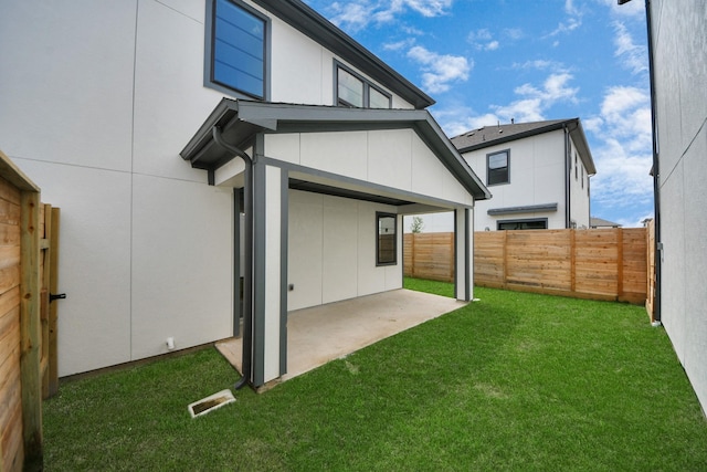 rear view of property with a fenced backyard, a patio area, visible vents, and a lawn