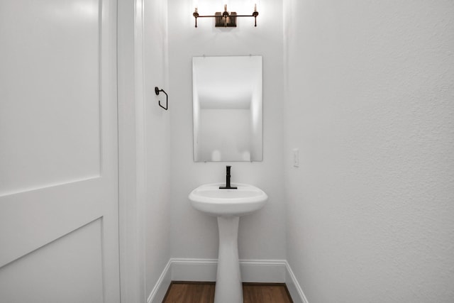 bathroom with baseboards and wood finished floors