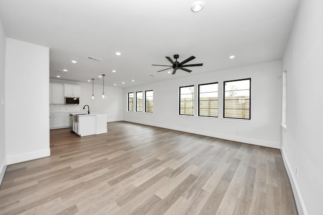 unfurnished living room featuring a ceiling fan, light wood-style floors, visible vents, and recessed lighting
