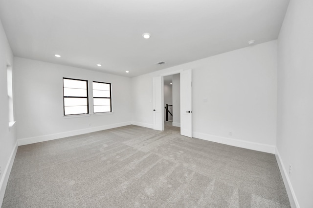carpeted empty room featuring baseboards, recessed lighting, and visible vents