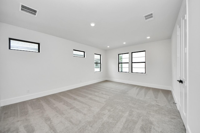 carpeted empty room with visible vents, baseboards, and recessed lighting