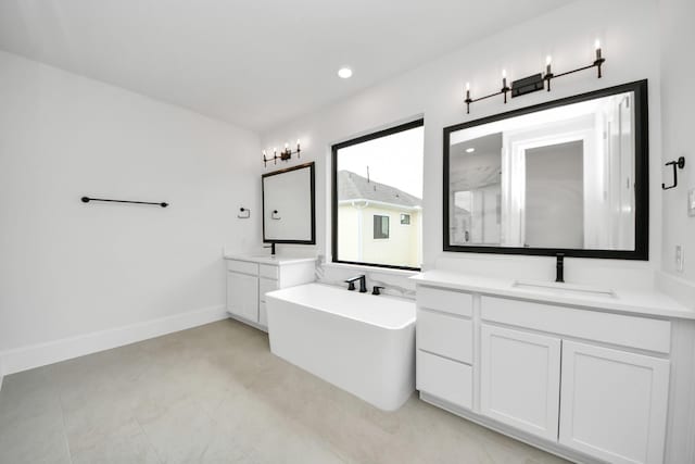 full bathroom featuring a sink, recessed lighting, a walk in shower, a soaking tub, and two vanities