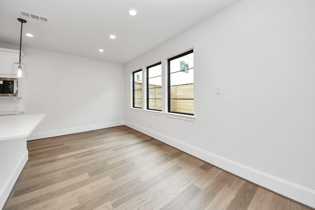 unfurnished dining area with light wood finished floors, baseboards, visible vents, and recessed lighting