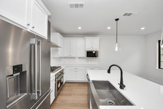 kitchen with recessed lighting, white cabinetry, appliances with stainless steel finishes, and a sink