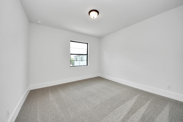 carpeted spare room with baseboards