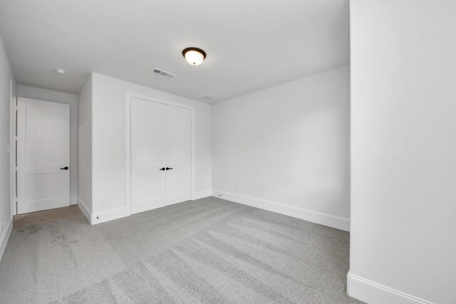 unfurnished bedroom featuring carpet, baseboards, a closet, and visible vents