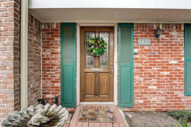 entrance to property featuring brick siding