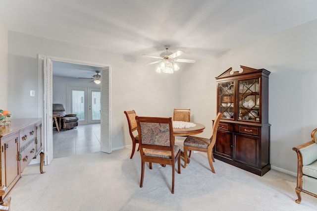 dining room with light colored carpet, baseboards, french doors, and a ceiling fan