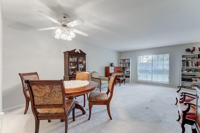 dining space featuring light carpet and ceiling fan