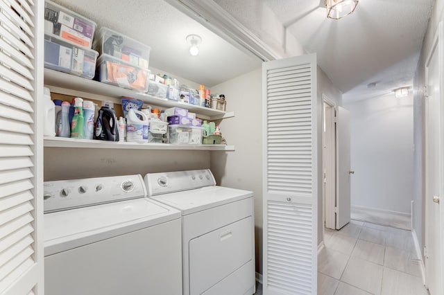 laundry room featuring laundry area, light tile patterned floors, baseboards, and washing machine and dryer