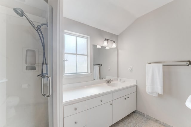 bathroom with vanity, vaulted ceiling, and a shower stall