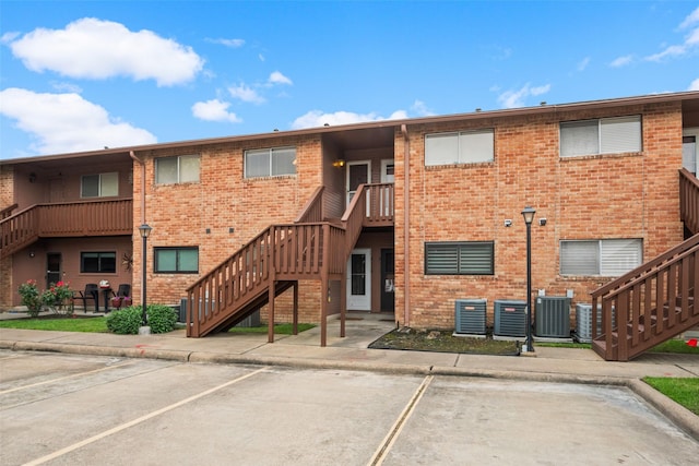 801 River Rd Unit F120, Montgomery, TX 77356 - view of property featuring uncovered parking, stairway, and central AC