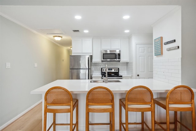 801 River Rd Unit F120, Montgomery, TX 77356 - kitchen with stainless steel appliances, a kitchen breakfast bar, light countertops, decorative backsplash, and ornamental molding