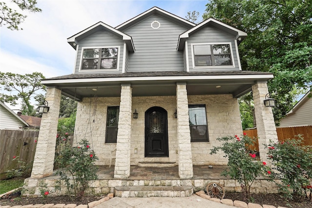 1316 Norham St, Houston, TX 77022 - view of front of property with stone siding, a porch, and fence