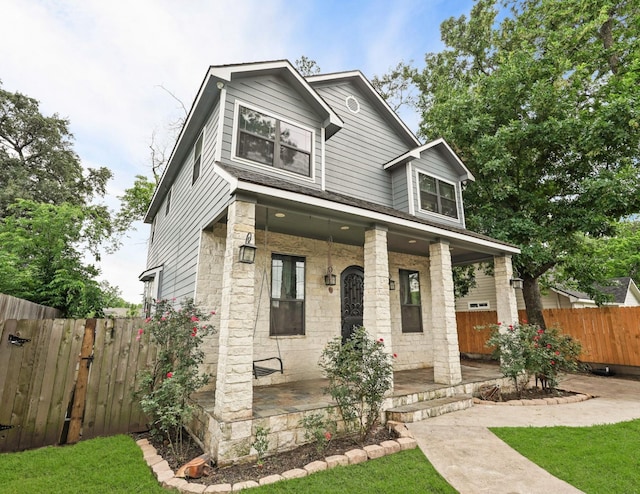 1316 Norham St, Houston, TX 77022 - craftsman-style home with stone siding, a porch, and fence