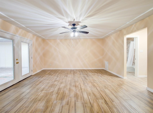 spare room with baseboards, ceiling fan, and wood finished floors