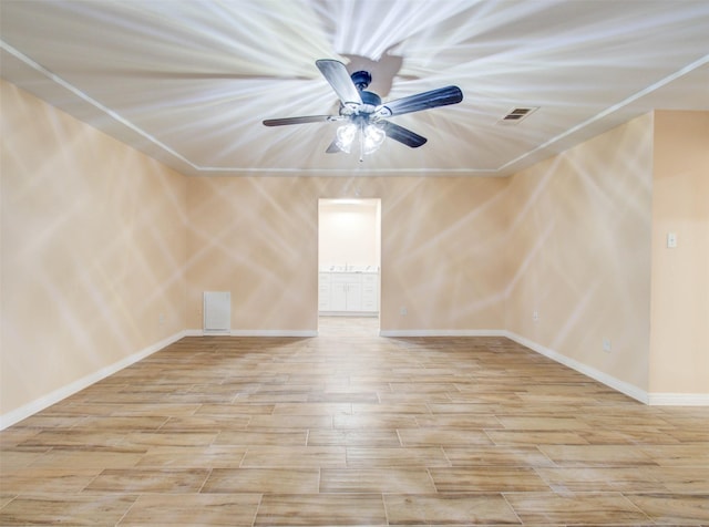 spare room featuring baseboards, ceiling fan, visible vents, and wood finished floors
