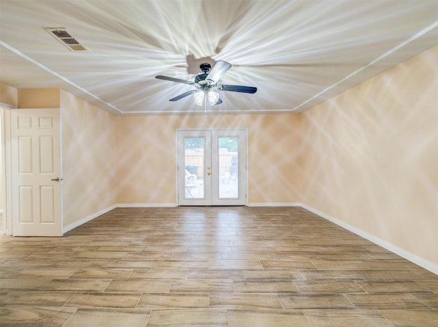 empty room with baseboards, french doors, visible vents, and wood finished floors