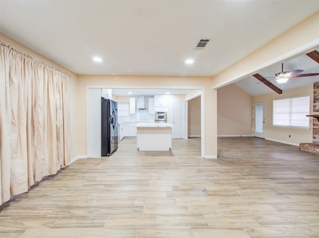 unfurnished living room with lofted ceiling with beams, light wood-type flooring, recessed lighting, ceiling fan, and baseboards