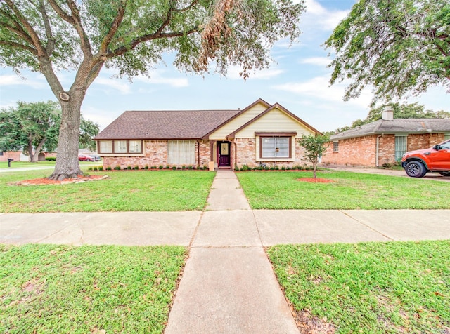 single story home with brick siding and a front yard