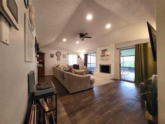 9406 Walnut Glen Dr, Houston, TX 77064 - living room featuring ceiling fan, dark wood finished floors, a brick fireplace, a textured ceiling, and baseboards