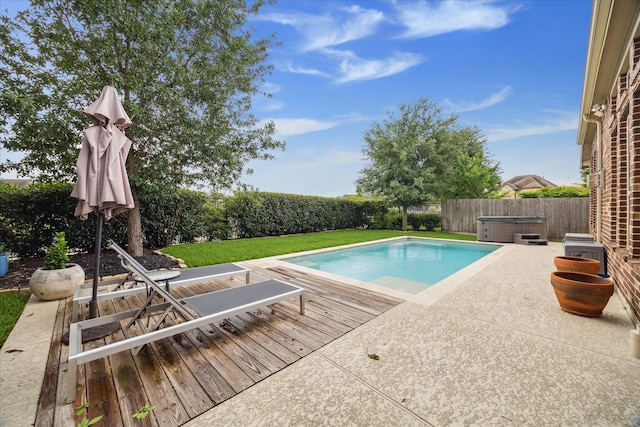 view of swimming pool with a hot tub, a deck, a yard, a patio, and a fenced backyard