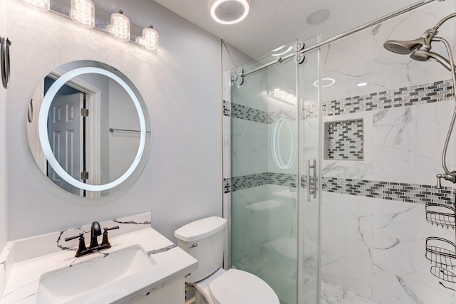 full bathroom with toilet, vanity, and a shower stall