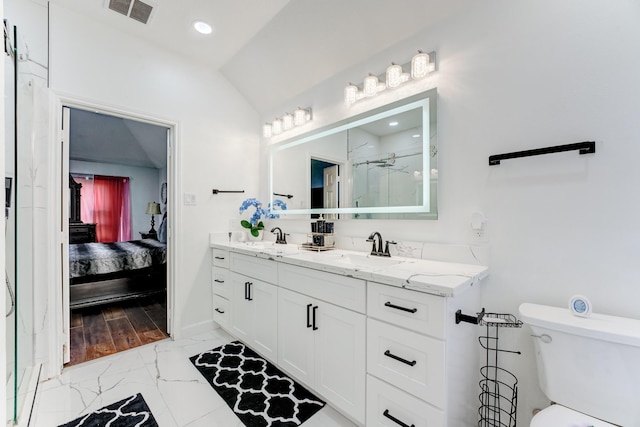 ensuite bathroom with marble finish floor, visible vents, a sink, connected bathroom, and vaulted ceiling