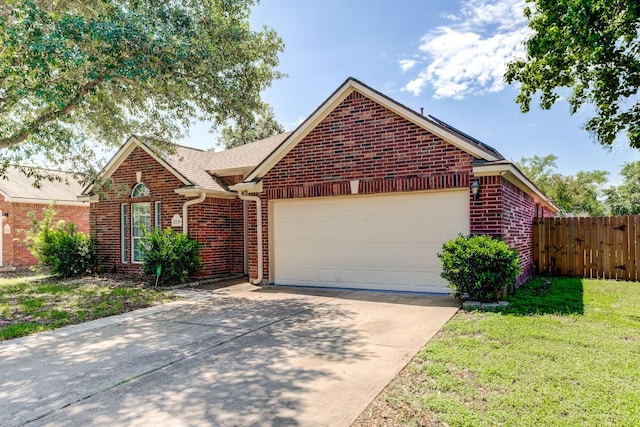 ranch-style home featuring fence, a garage, brick siding, and driveway
