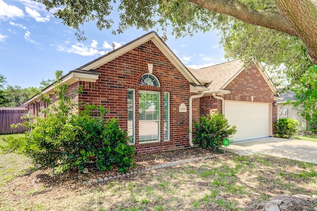 ranch-style home with concrete driveway, brick siding, a garage, and fence