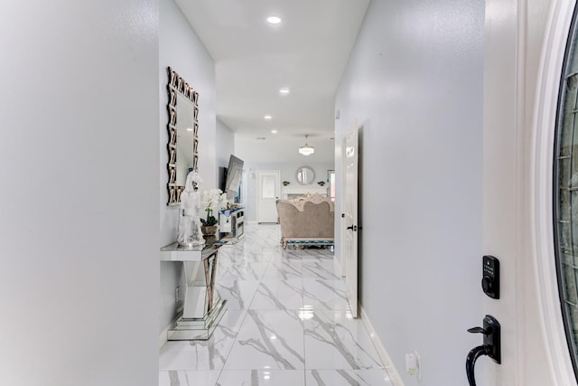 hallway featuring baseboards, marble finish floor, and recessed lighting