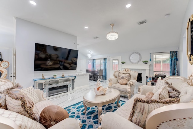 living area featuring visible vents, a glass covered fireplace, vaulted ceiling, marble finish floor, and recessed lighting