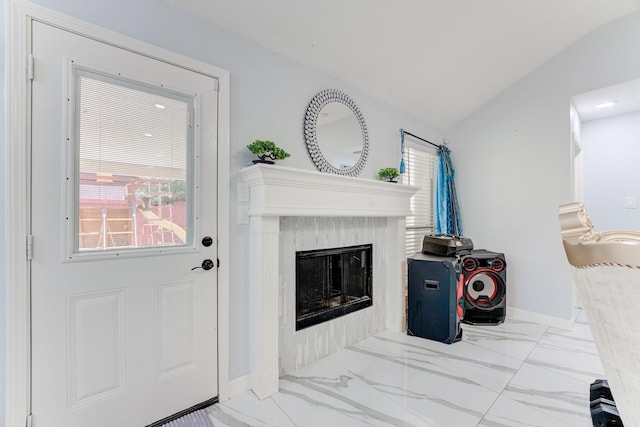 living area with baseboards, marble finish floor, lofted ceiling, and a fireplace