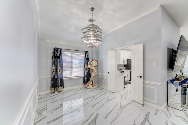 foyer with a wainscoted wall, marble finish floor, visible vents, crown molding, and an inviting chandelier