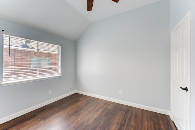 spare room with vaulted ceiling, baseboards, dark wood-style flooring, and a ceiling fan