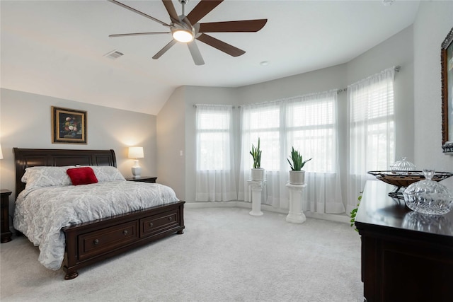 bedroom featuring light carpet, visible vents, baseboards, ceiling fan, and vaulted ceiling