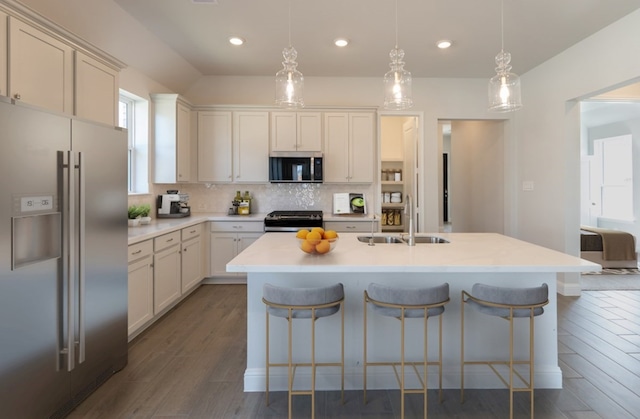 19714 Palomino Prairie Trl, Tomball, TX 77377 - kitchen featuring a kitchen bar, a sink, stainless steel appliances, dark wood-style flooring, and decorative backsplash
