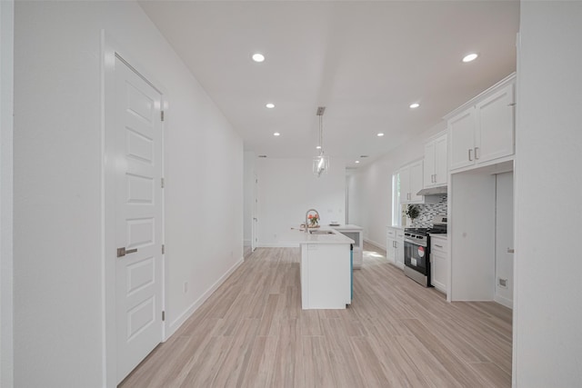 7307 W Knoll St, Houston, TX 77028 - kitchen with stainless steel gas range, recessed lighting, a sink, and white cabinets