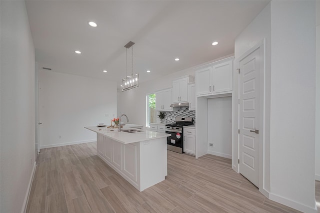 7307 W Knoll St, Houston, TX 77028 - kitchen with a sink, white cabinetry, stainless steel range with gas cooktop, backsplash, and under cabinet range hood