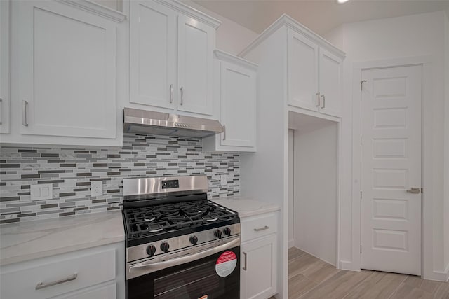 7307 W Knoll St, Houston, TX 77028 - kitchen with under cabinet range hood, gas stove, decorative backsplash, white cabinets, and light wood-type flooring