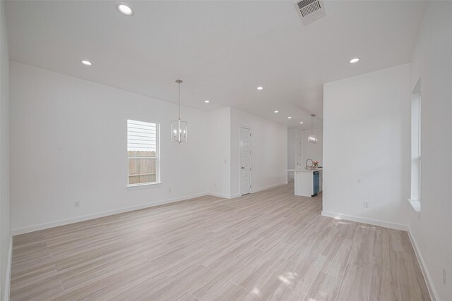 7307 W Knoll St, Houston, TX 77028 - unfurnished living room with light wood finished floors, visible vents, baseboards, a chandelier, and recessed lighting
