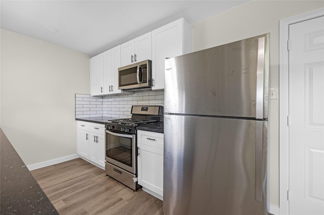 6727 Winding Trace Dr, Houston, TX 77086 - kitchen featuring appliances with stainless steel finishes, light wood-style floors, white cabinets, and decorative backsplash