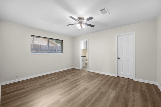 6727 Winding Trace Dr, Houston, TX 77086 - unfurnished bedroom with wood finished floors, baseboards, ensuite bath, and ceiling fan