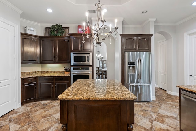 8483 Majestic Lake Ct, Montgomery, TX 77316 - kitchen featuring dark brown cabinets, light stone counters, a chandelier, arched walkways, and appliances with stainless steel finishes
