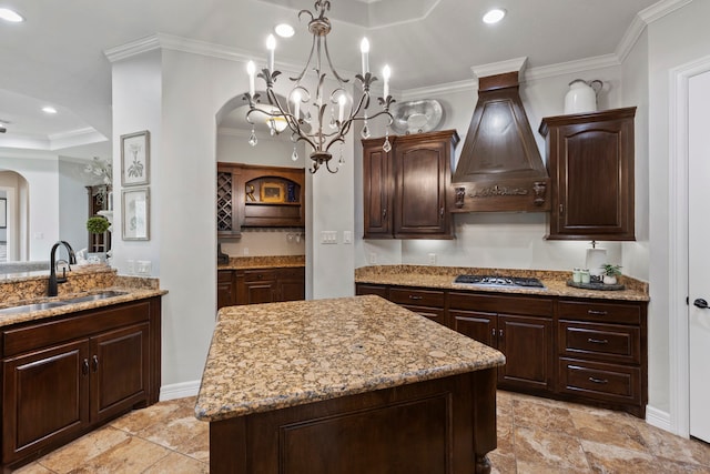 8483 Majestic Lake Ct, Montgomery, TX 77316 - kitchen with light stone countertops, stainless steel gas stovetop, a sink, premium range hood, and arched walkways