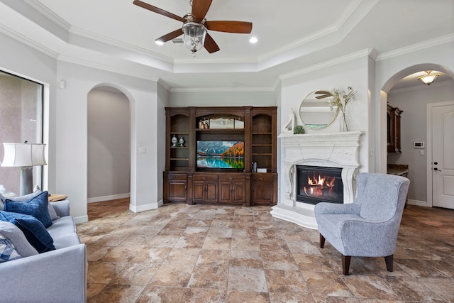 8483 Majestic Lake Ct, Montgomery, TX 77316 - living area with a tray ceiling, ceiling fan, arched walkways, and a glass covered fireplace