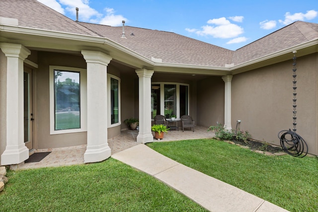 8483 Majestic Lake Ct, Montgomery, TX 77316 - doorway to property featuring a lawn, stucco siding, and a shingled roof